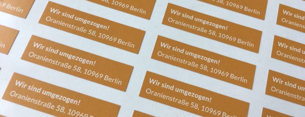 Auf dem Bild sind Sticker mit der neuen Adresse der BAG RelEx zu sehen: Oranienstraße 58, 10969 Berlin